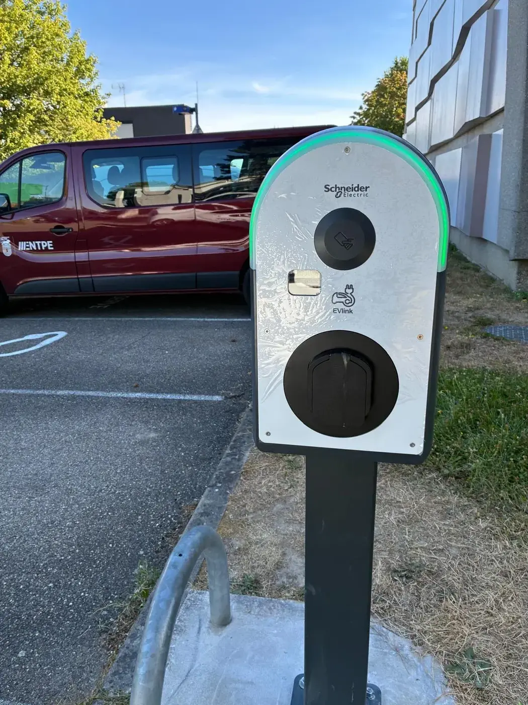 Borne de recharge sur pied installée en bordure de parking professionnel
