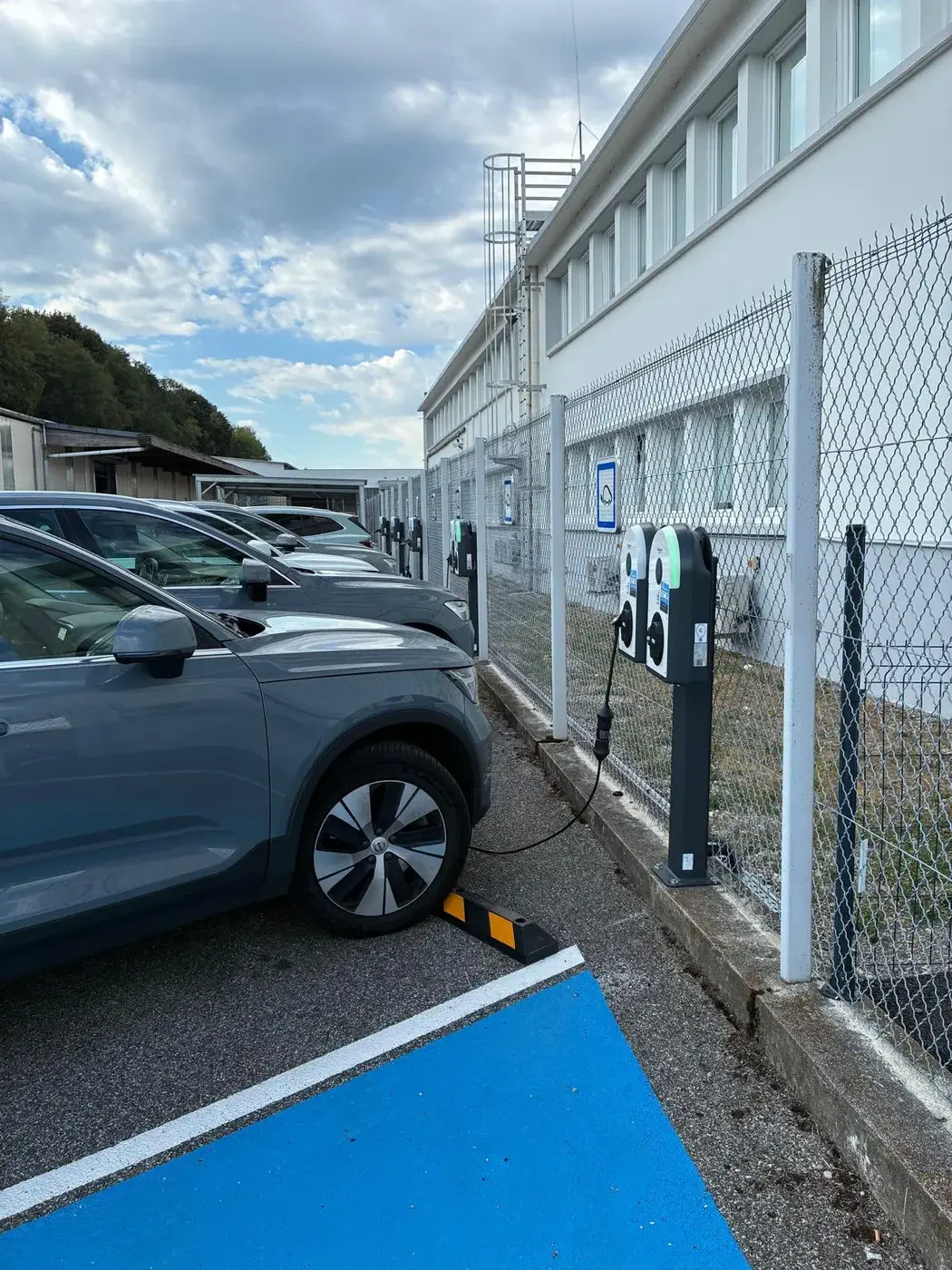 Véhicules électriques en charge sur des bornes installées sur un parking d'entreprise