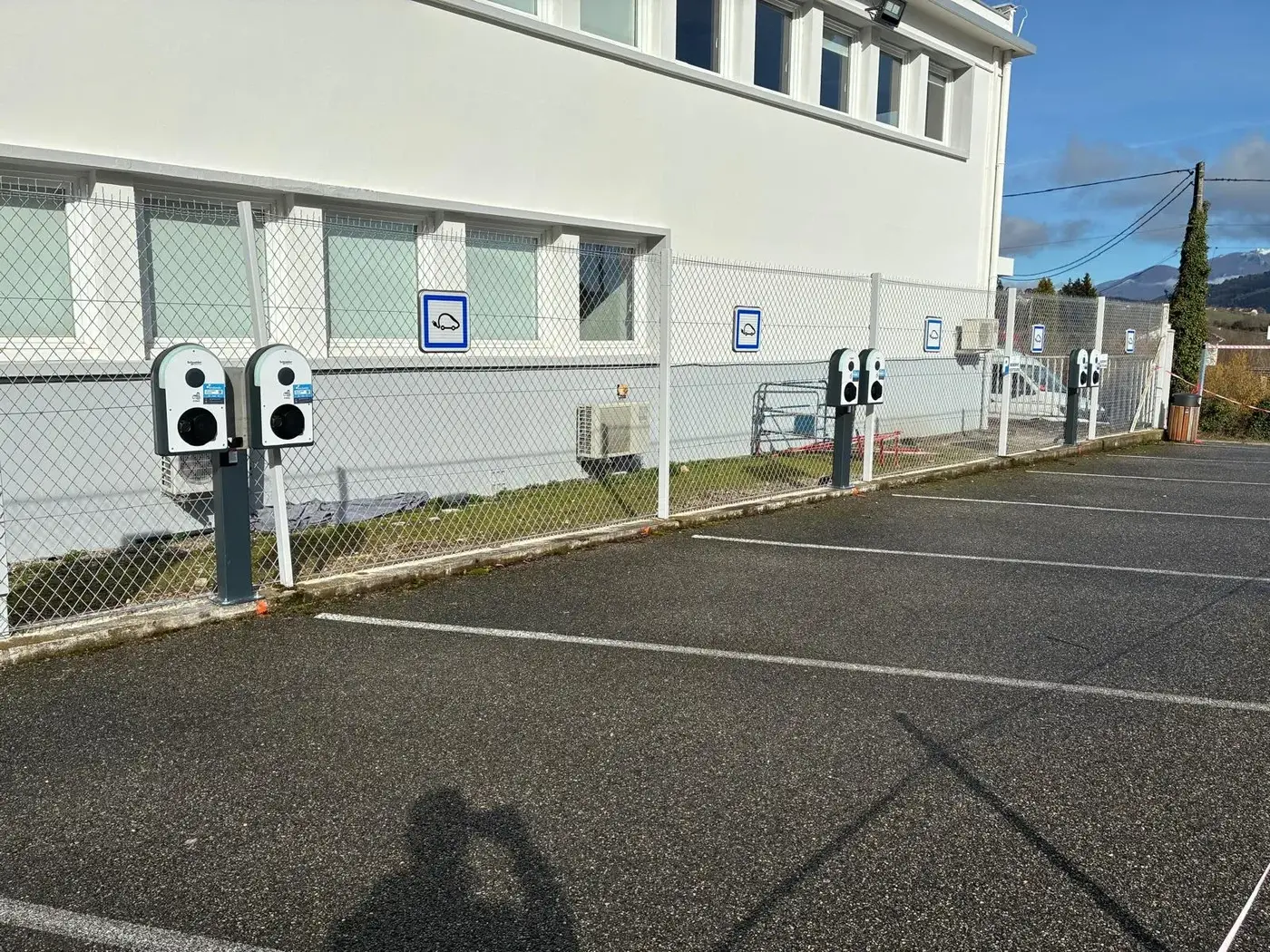 Bornes de recharge installées le long du parking d'un bâtiment d'entreprise