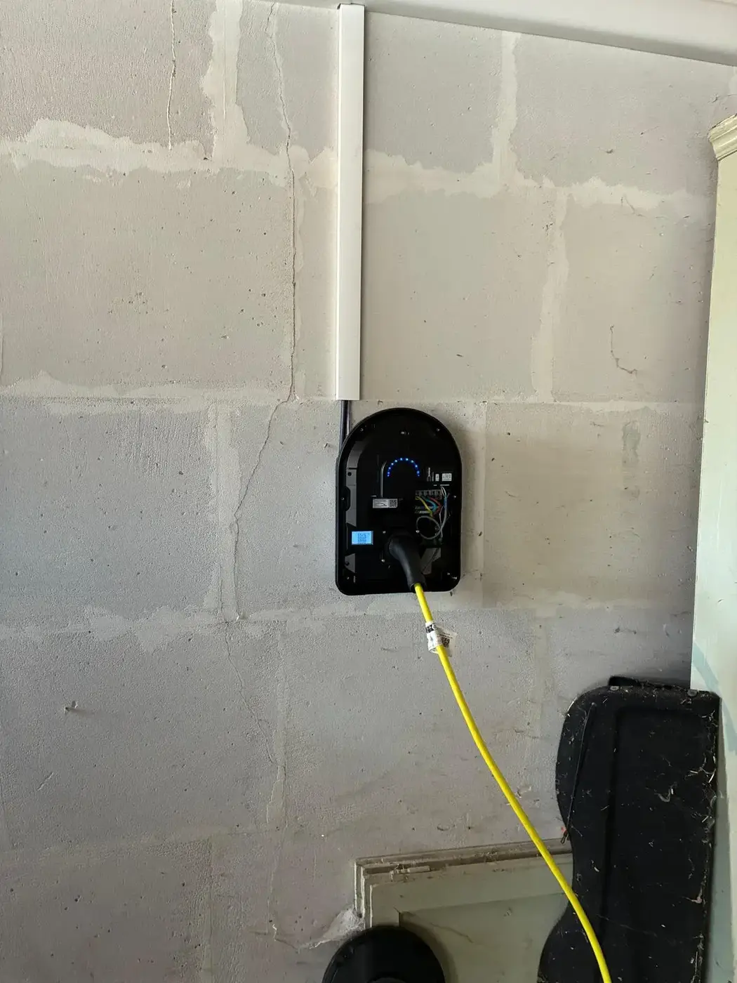 Borne de recharge murale installée dans un garage avec câble de charge